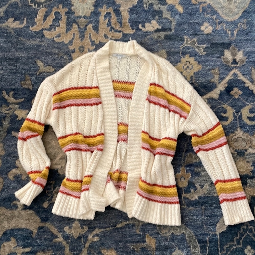 This is a cream Madewell cardigan with rust red, green, pink, & yellow stripes.